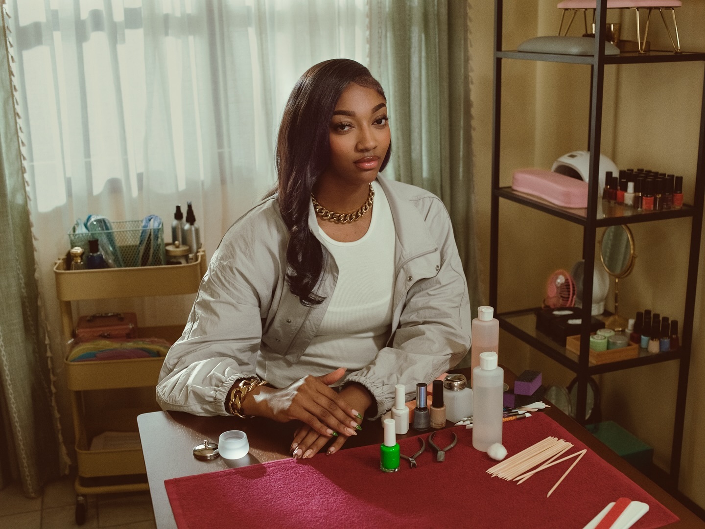Woman seated at a manicure table in a nail salon